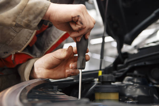 istock Mechanic with new car headlight in a workshop 932153164