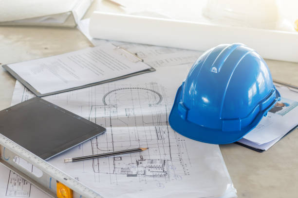 istock The safety helmet and the blueprint on table at construction site 932154200