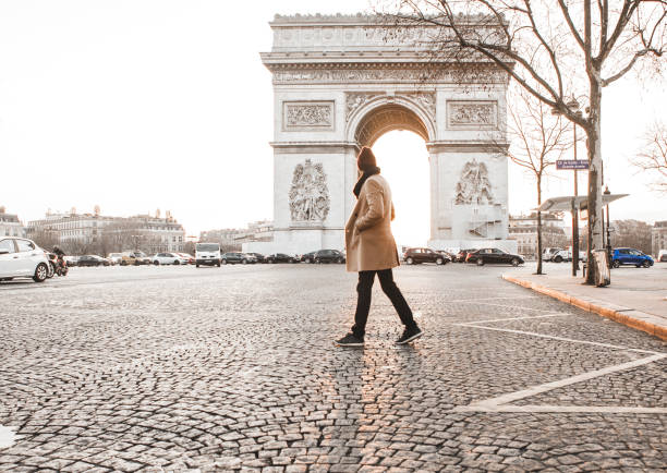 man walking in front of arc de triomphe - paris france arc de triomphe france french culture imagens e fotografias de stock