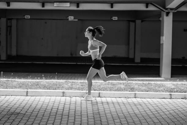 istock Female runner jogging under the traffic overpass.City environment. 932165510