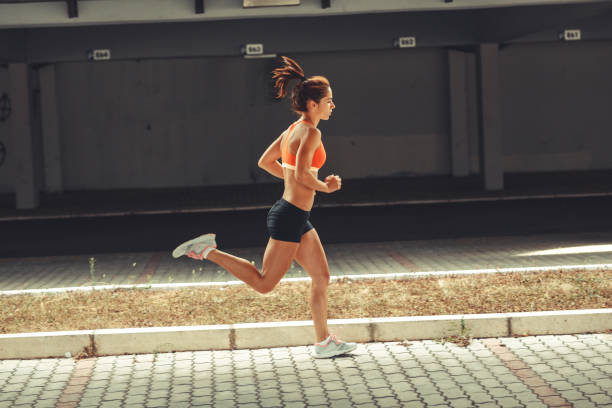 istock Female runner jogging under the traffic overpass.City environment. 932168486