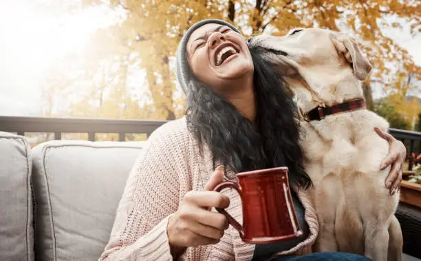 Shot of a young woman relaxing with her dog outside