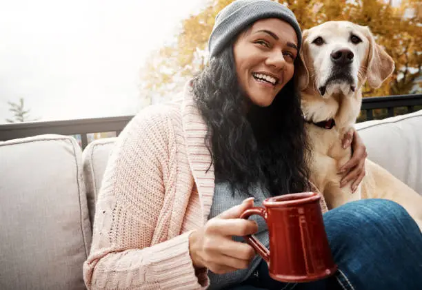 Shot of a young woman relaxing with her dog outside