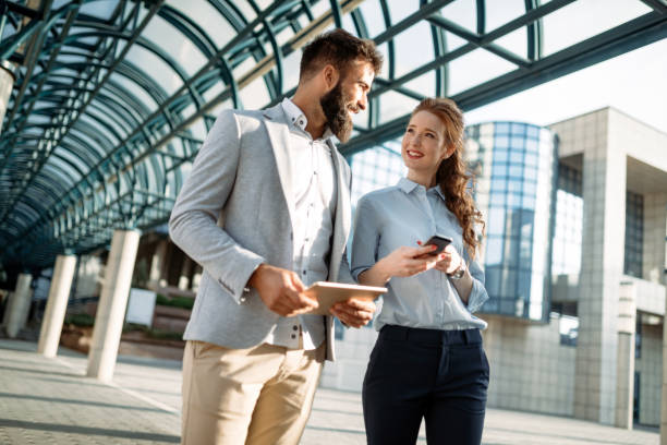 istock Business man and woman working outdoors with tablet computer in front of office 932184800