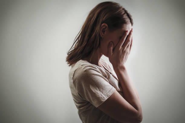 Portrait of depressed woman, covering face with her hands, side view Portrait of depressed woman, covering face with her hands, side view guilt stock pictures, royalty-free photos & images