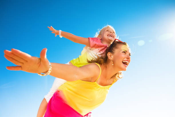 istock happy trendy mother and child on seashore having fun time 932195448