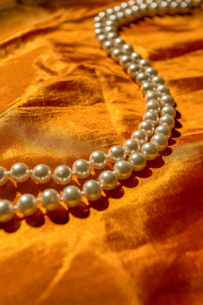 istock Pearl necklace on the orange cloth 932202794