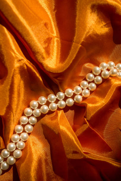 istock Pearl necklace on the orange cloth 932203604