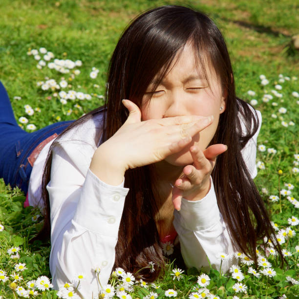 istock Asian woman with allergy in spring lying on grass closeup 932212544