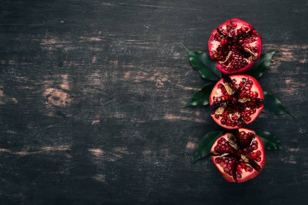 istock Fresh pomegranate. On a black wooden background. Top view. Copy space. 932212622