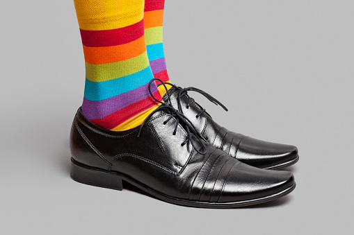 Multi colored socks and elegance shoes on grey background. This file is cleaned and retouched.