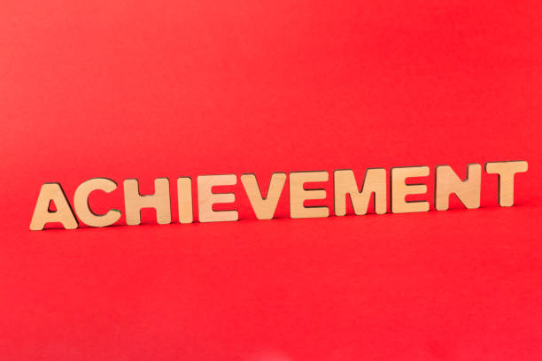 istock Achievement inscription on red background 932215118