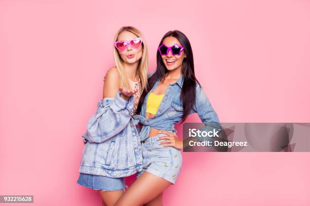 I Like You Beautiful Playful Cheerful Women Dressed In Fashionable Stylish Shorts Shirt Jacket Top Funny Star And Heart Glasses Are Embracing Sending Airkiss Isolated On Bright Pink Background Stock Photo - Download Image Now
