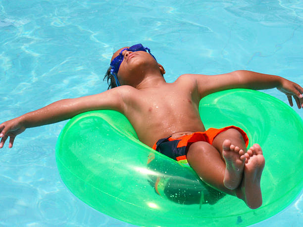 young boy jumping into a pool