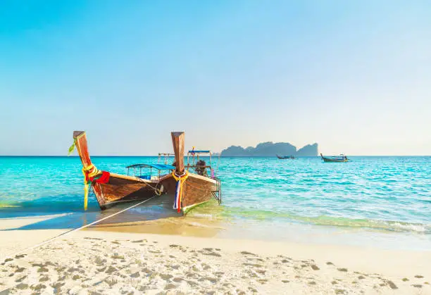 Two traditional thai longtail wooden boats at famous sunset Long Beach, Thailand, Koh Phi Phi Don island, Krabi province, Andaman sea