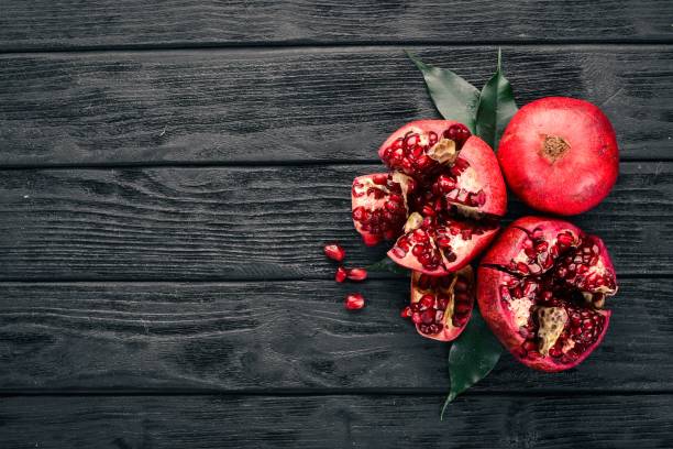 istock Fresh pomegranate. On a black wooden background. Top view. Copy space. 932231754