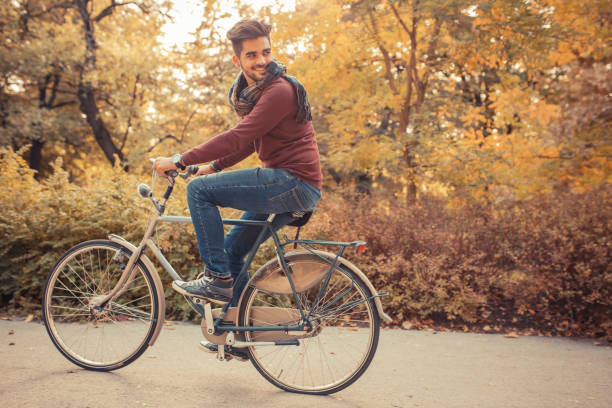 istock Young handsome man riding bicycle on street. 932232524