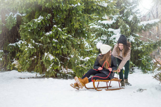 istock Sister twins having fun on snow 932237514