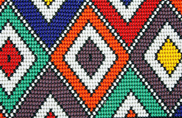 African beads Ndebele beadwork detail: from South Africa that I bought from illegal immigrants from Malawi in 2008 at a curio market near Hartebeespoort Dam, one hour from Johannesburg. This pattern is called after the Ndebele tribe that paint these blocks and triangles on their huts as ritual from folklore. The design is not unique or original, has no. copyright, it is a mere replica of a pattern used by the Ndebele tribe. The men from Malawi know that this colourful pattern sell well to tourists, they make a few and then take the money back to their home country. This design is popular and used very often as a background for African Safari logos or in a light box and has no copyright bead photos stock pictures, royalty-free photos & images