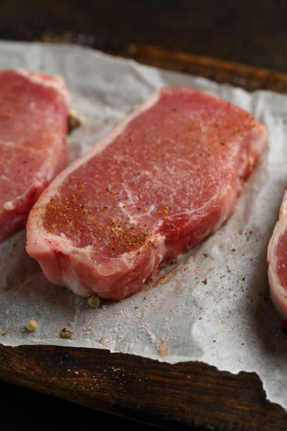 istock Uncooked fresh steaks on wood, food closeup 932253080
