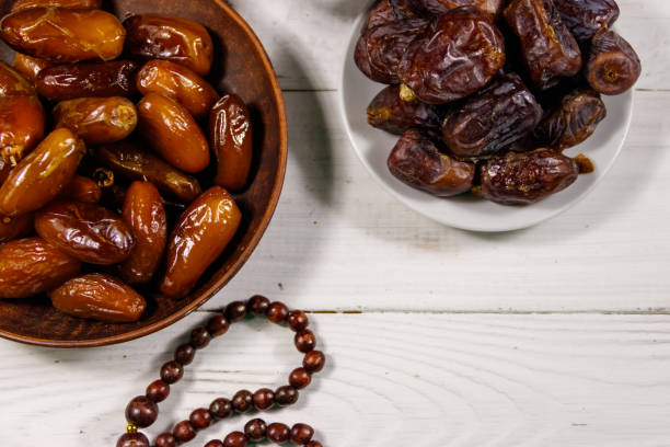 istock Dates fruit and prayer beads on white wooden table. Top view 932253532