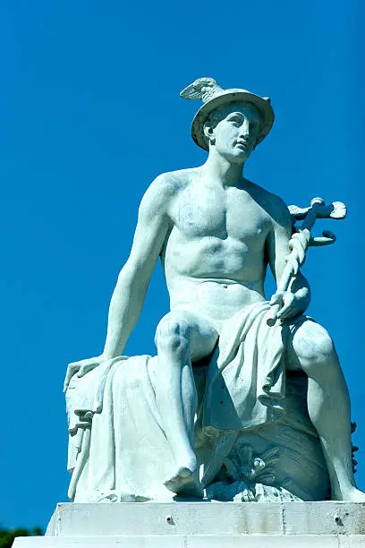 Photo of A light blue statue of Hermes, outside on a clear day