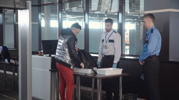 istock Guard checking passenger bag in airport 932263608