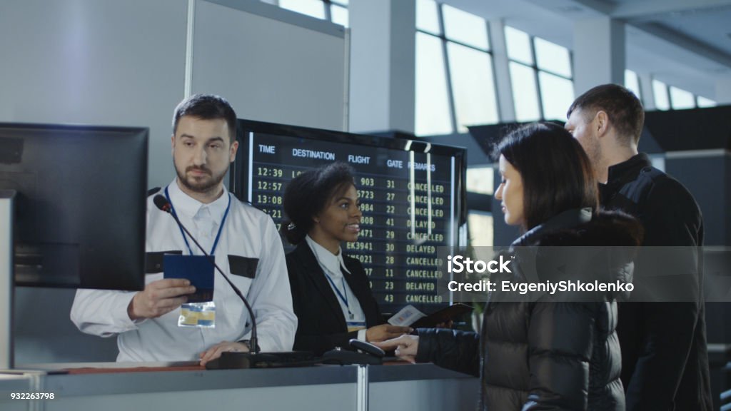 Airport workers checking documents at control point Diverse employees of airport checking passports and biometric data working with passengers. Airport Stock Photo