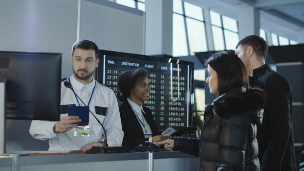 airport workers checking documents at control point - airport check in counter imagens e fotografias de stock