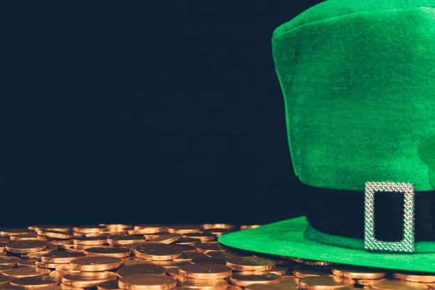 istock green hat on golden coins isolated on black, st patricks day concept 932264130