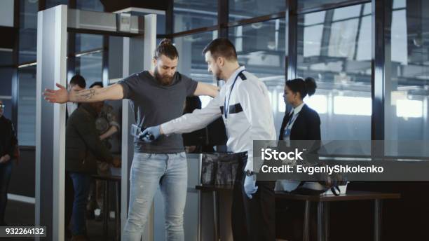 Agente De Seguridad Acariciando A Un Pasajero Masculino Foto de stock y más banco de imágenes de Aeropuerto