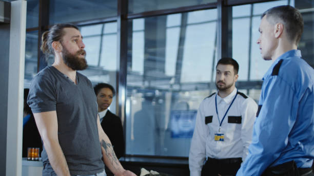 istock Airport worker checking passenger with metal detector 932264148