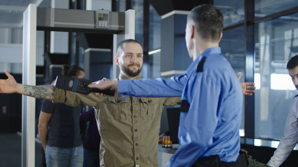 istock Airport worker checking passenger with metal detector 932264236