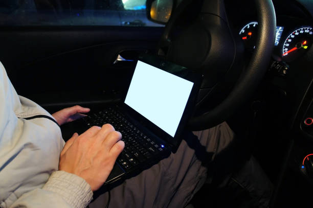 istock Male hand with a laptop in the car. mockup. 932271640