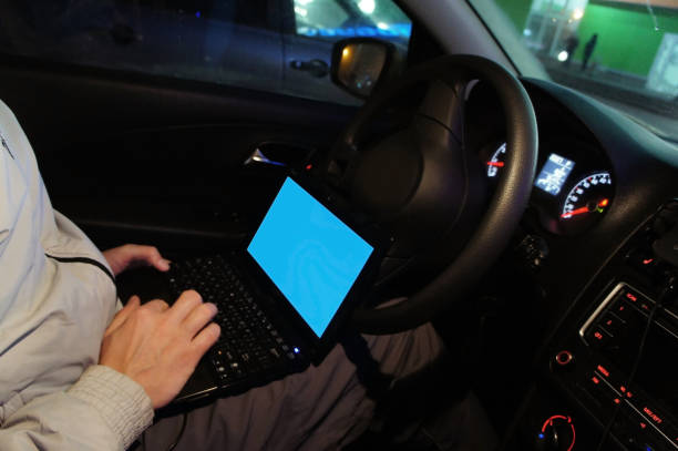istock Male hand with a laptop in the car. mockup. 932271688