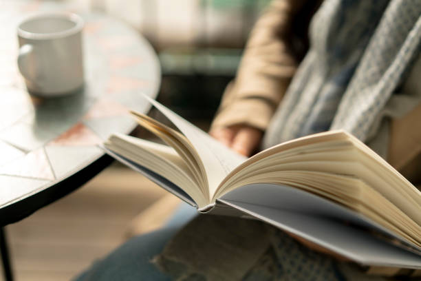 livre de lecture tout en buvant du café - lire photos et images de collection