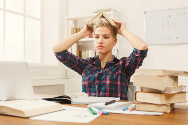 istock Student girl studying at table full of books 932272376