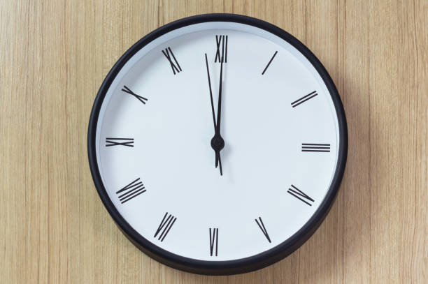 istock black and white clock on wooden wall, lunch time, roman number clock 932275556