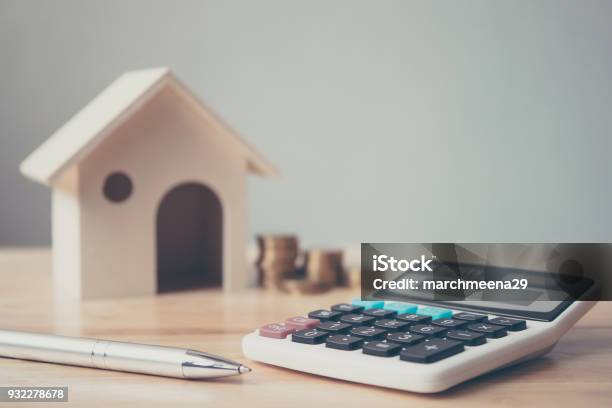 Calculator With Wooden House And Coins Stack And Pen On Wood Table Property Investment And House Mortgage Financial Concept Stock Photo - Download Image Now