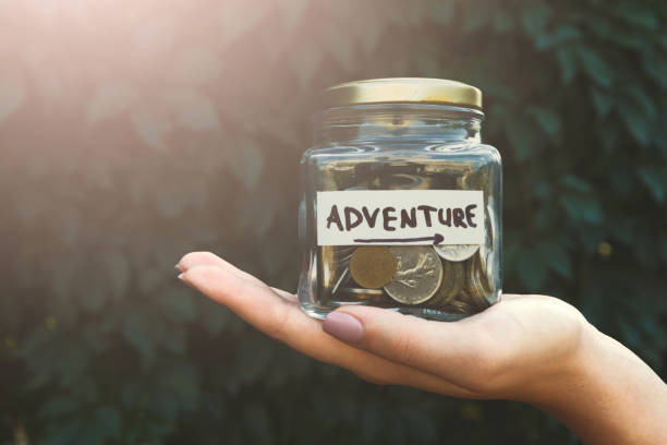 istock Hand holding glass jar with coins for adventure 932278830