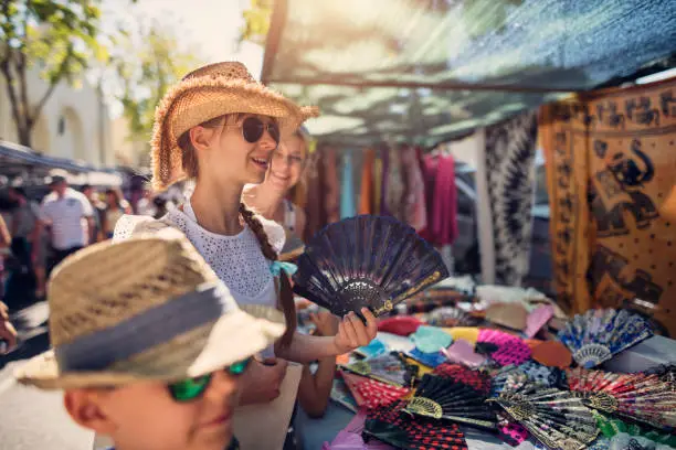 Tourist family buying souvenirs on flea market in Andalusia, Spain. Teenage girl is browsing selection of spanish fans.
Nikon D810