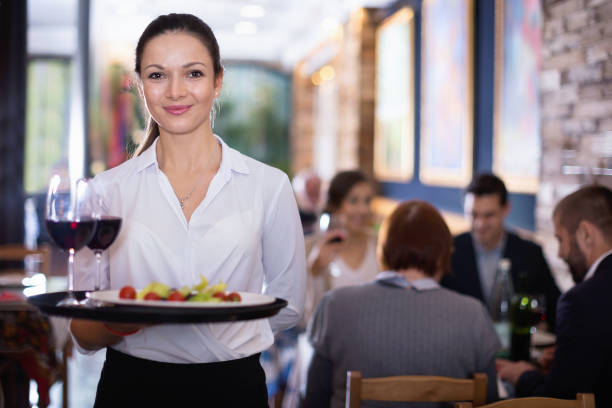 istock Professional waitress holding serving tray for restaurant guests 932279556