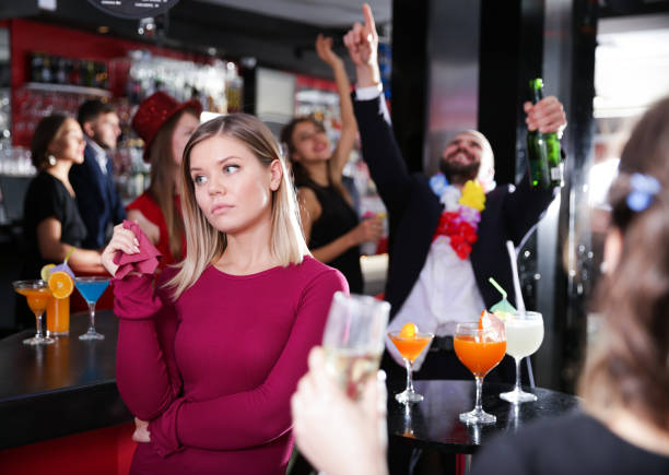 Offended woman with drunk man on party at nightclub Offended young woman on background with drunk man on party at nightclub vex nightclub stock pictures, royalty-free photos & images