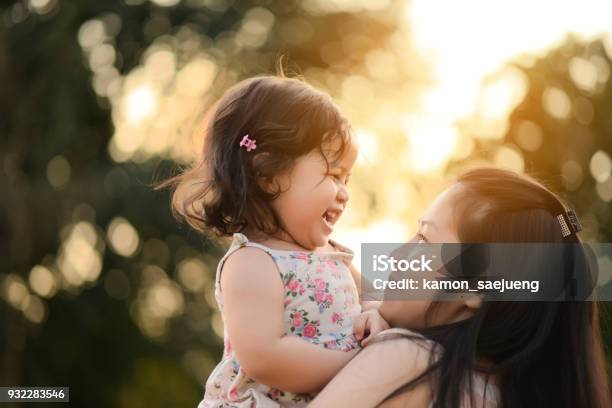 Sweet Beautiful Baby Girl With Hug Of Mother And Playing Happy Loving Family Kissing And Hugging Stock Photo - Download Image Now