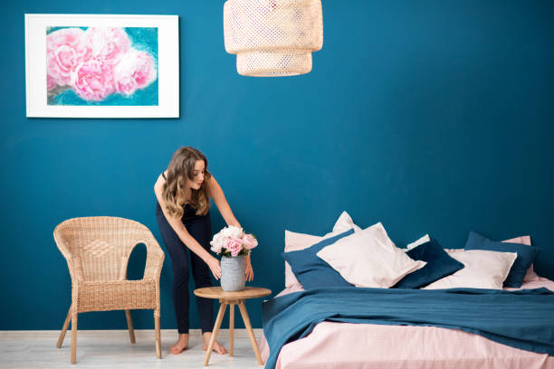 woman with flowers at home - attractive female indoors lifestyles clean imagens e fotografias de stock