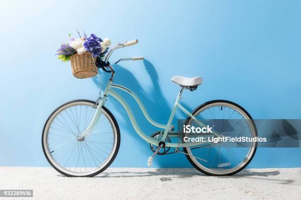 Photo libre de droit de Vue Latérale Du Vélo Avec Des Fleurs Dans Le Panier Devant Mur Bleu banque d'images et plus d'images libres de droit de Vélo