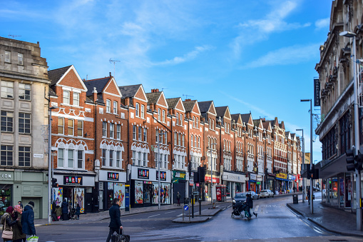 London, UK - 26 December, 2017: Store fronts on high street in Wimbledon, South London. London is the capital city of England in the United Kingdom and plays host to an average of over 18 million tourists per year.