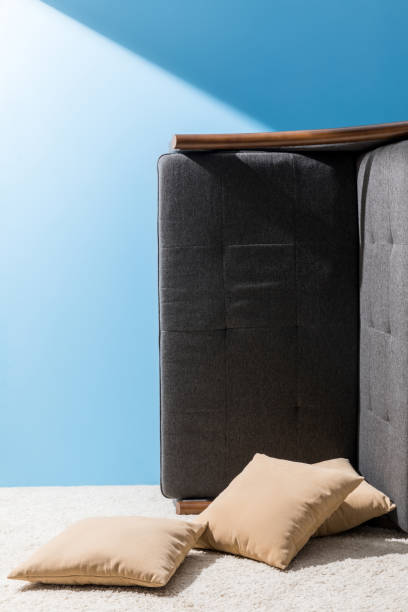 istock couch with pillows flipped on side in front of blue wall 932289522
