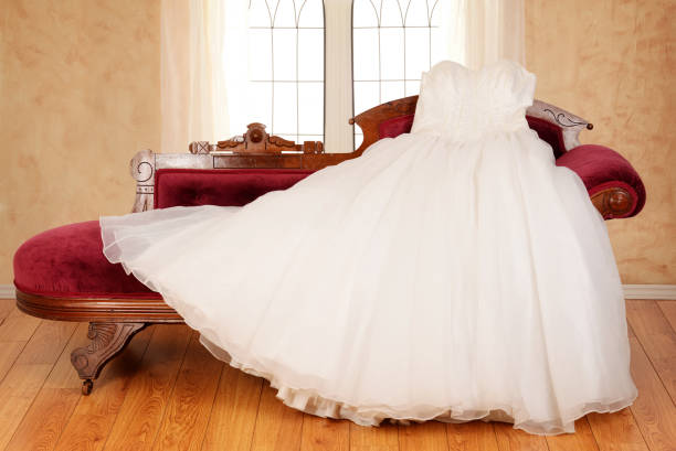 tulle wedding dress laying on chaise lounge tulle wedding dress laying on chaise lounge with window in background red evening gown mannequin indoors stock pictures, royalty-free photos & images