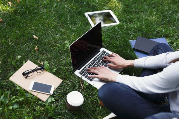 istock Young pensive woman using laptop in park 932301930